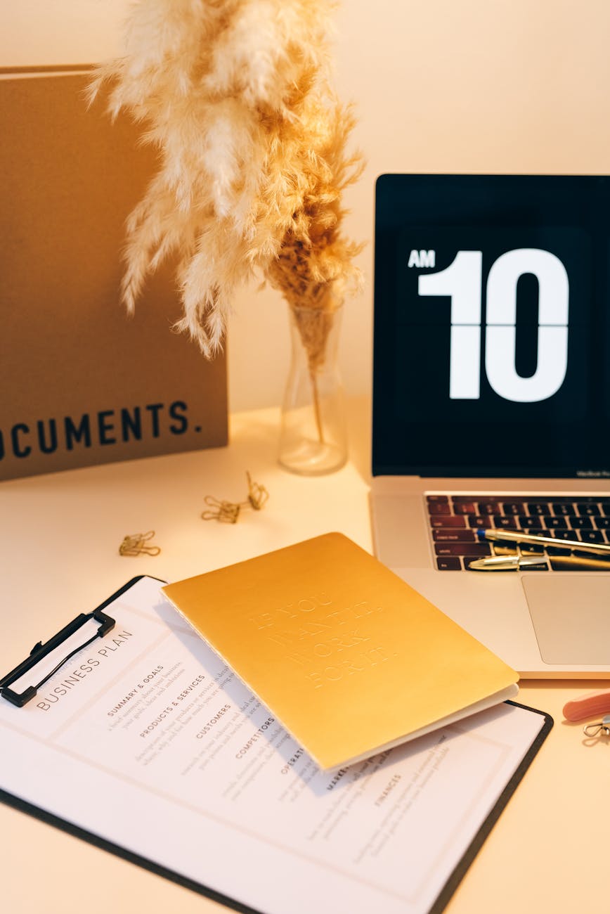 documents pens and laptop on a desk